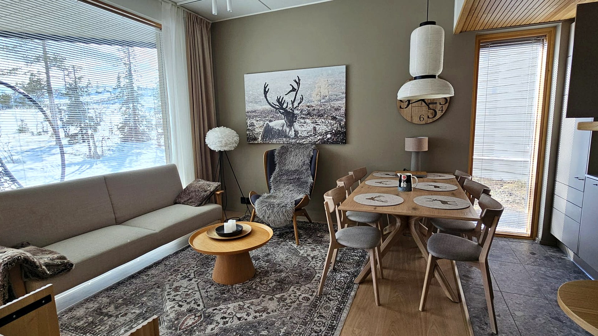 Cozy luxury living room with large windows overlooking a snowy Lapland fell landscape
